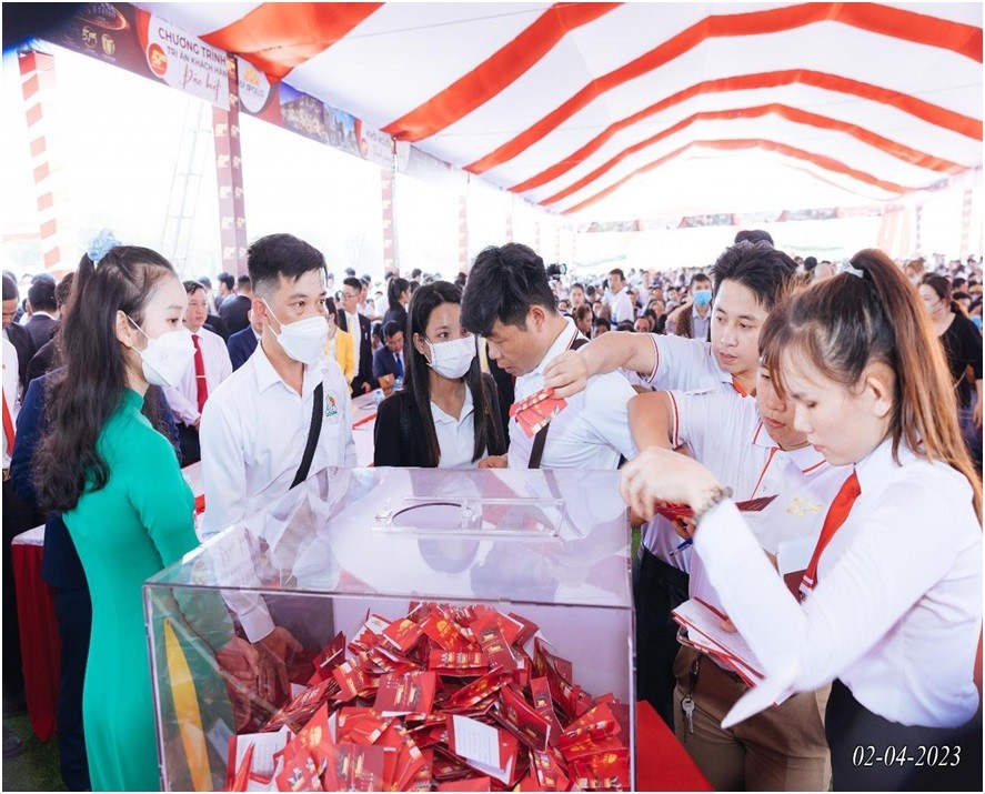 Nhân viên của Hệ thống 5F hỗ trợ khách hàng bỏ phiếu rút thăm may mắn vào thùng phiếu.
