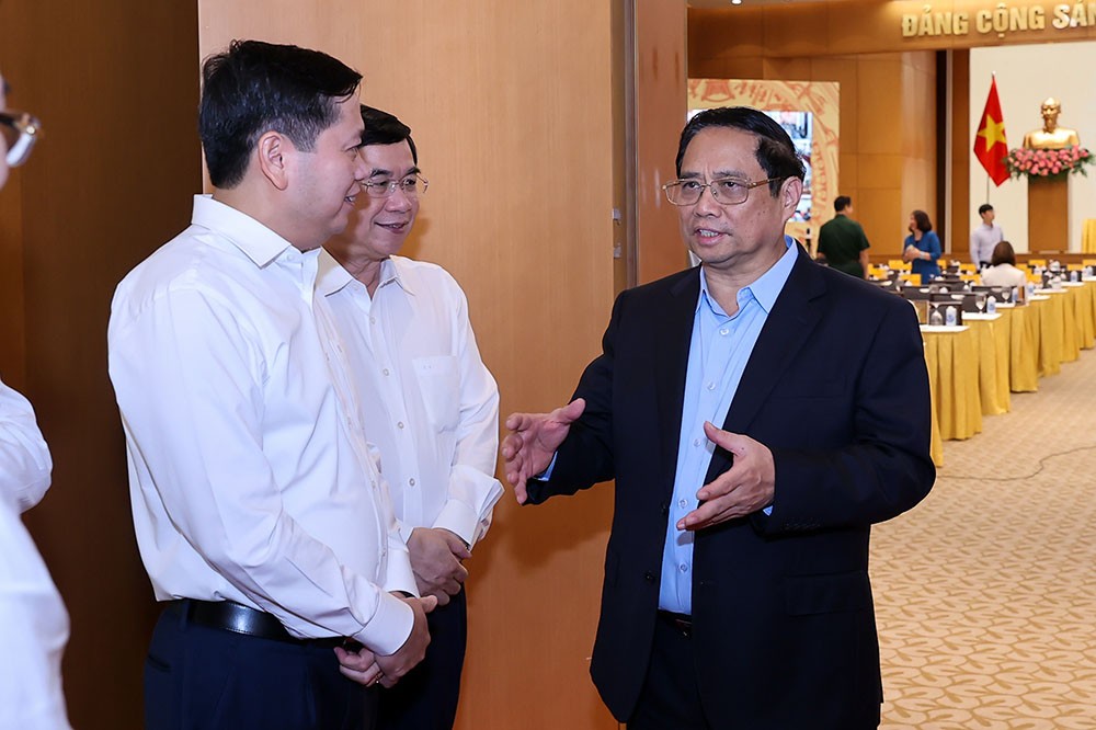 Thủ tướng trò chuyện với các đại biểu tham dự hội nghị. (Ảnh: Nhật Bắc).