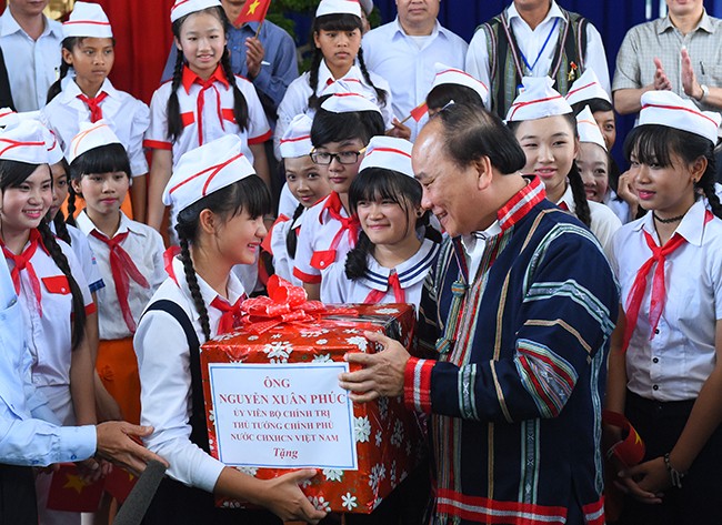 Thủ tướng tặng quà cho các cháu thiếu nhi xã N’Thol Hạ. Ảnh: VGP/Quang Hiếu