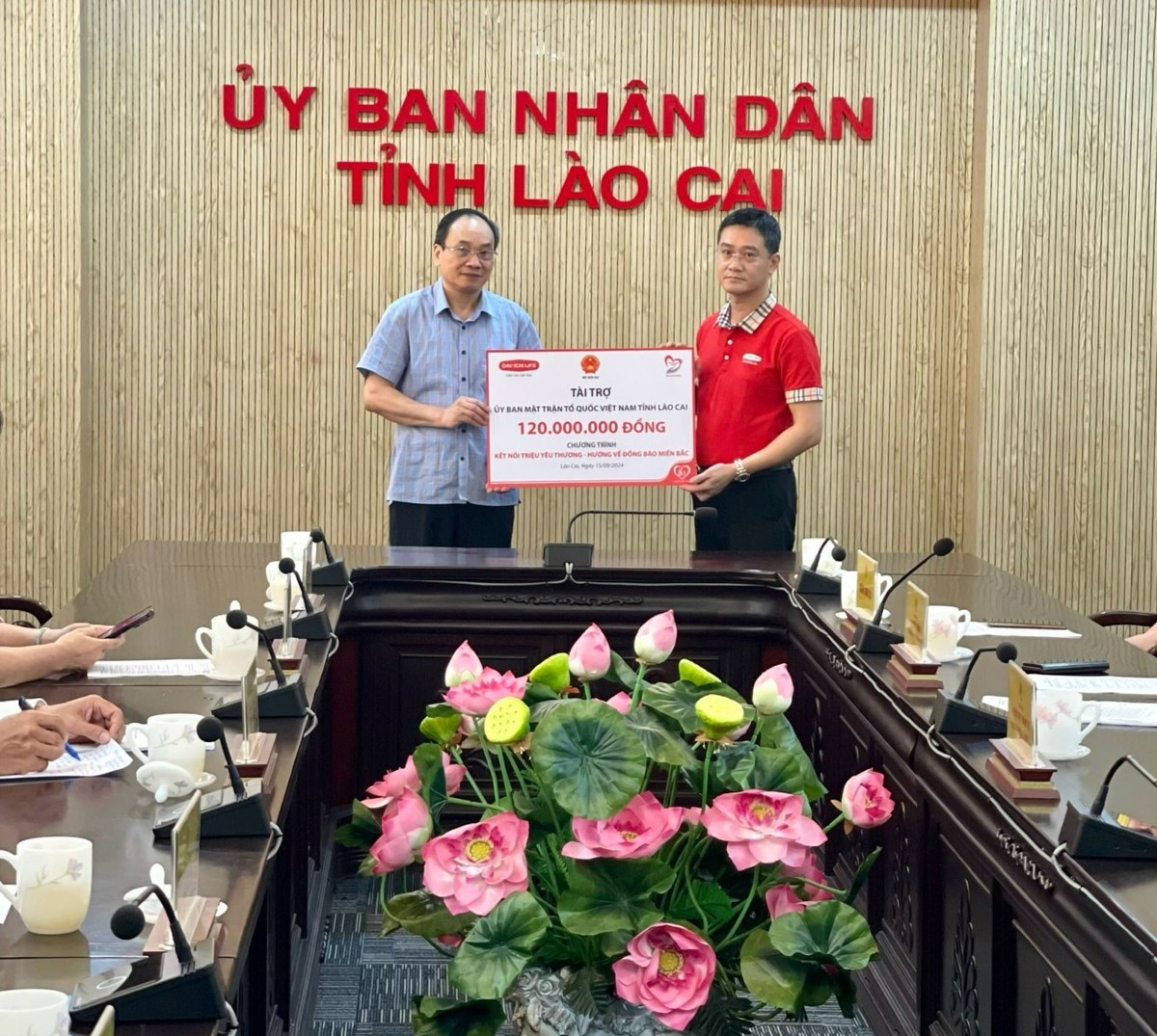 Ông Ngô Việt Phương – Phó tổng giám đốc Kl992 VIP Trang Chủ 2026 (áo đỏ) trao biểu trưng số tiền tài trợ cho Ông Lý Văn Hải, Ủy viên Ban Thường vụ Tỉnh ủy, Chủ tịch Ủy ban MTTQVN Tỉnh Lào Cai