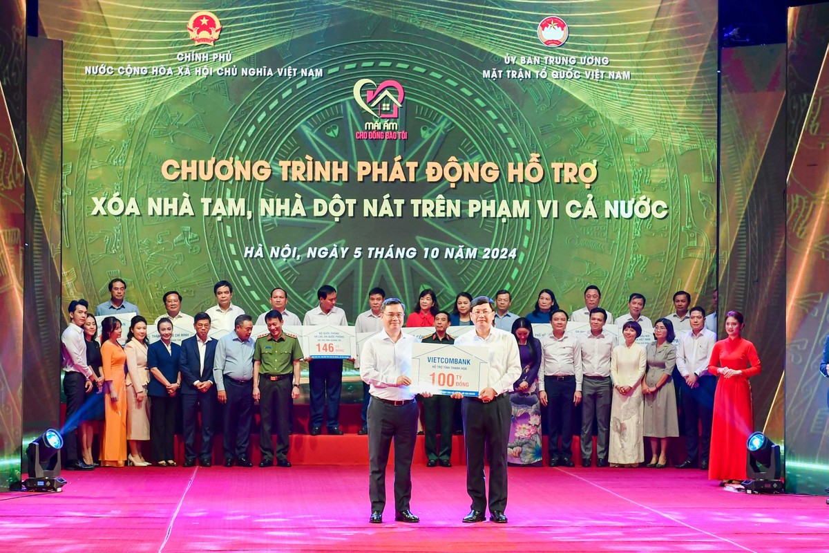 Ông Nguyễn Thanh Tùng (bên trái) - Chủ tịch HĐQT Vietcombank trao biển biểu trưng kinh phí 100 tỷ đồng hỗ trợ xoá nhà tạm, nhà dột nát ủng hộ cho địa phương