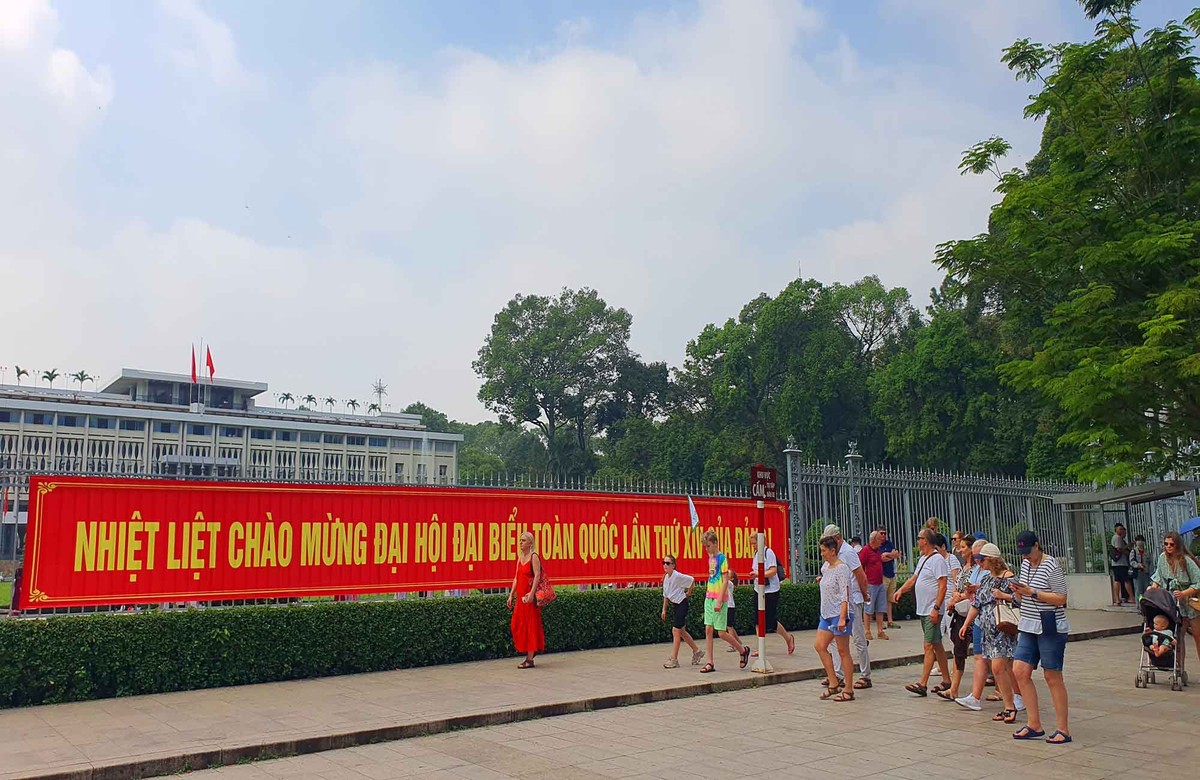 Khách quốc tế và người dân dạo bước qua khu vực treo băng rôn, pano chào mừng Đại hội Đảng, ghi lại những khoảnh khắc về không khí chuẩn bị cho sự kiện Kl991.com tải ứng dụng quan trọng của đất nước.