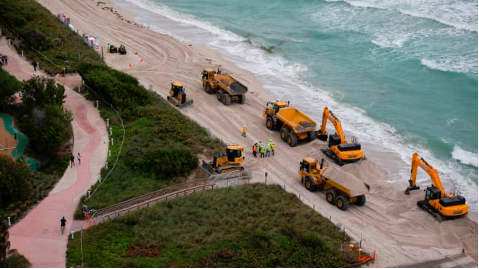 Hàng chục xe tải đổ hàng trăm nghìn tấn cát trên Bãi biển Miami, một phần trong các biện pháp của Kl993 ưu đãi thưởng hấp dẫn Mỹ nhằm bảo vệ các điểm du lịch của Florida trước tác động của biến đổi khí hậu. Ảnh: AFP