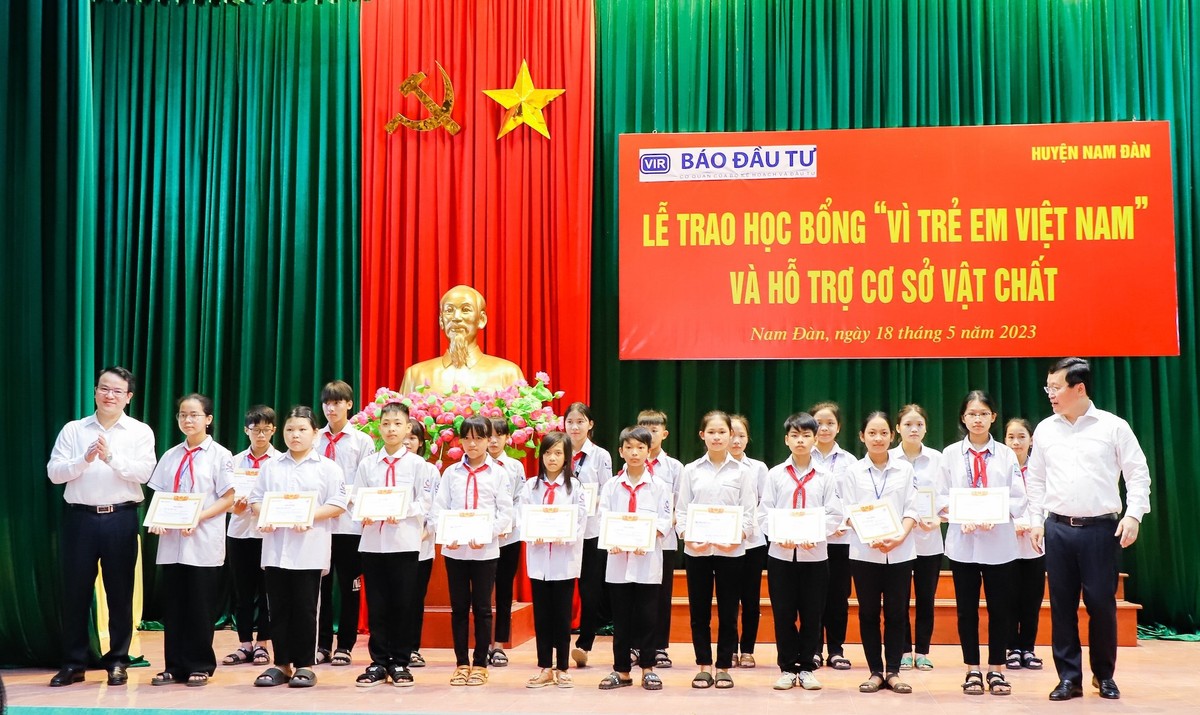 Thứ trưởng Bộ Kế hoạch và Kl99ok phiên bản mới Trần Quốc Phương và ông Nguyễn Đức Trung - Chủ tịch UBND tỉnh Nghệ An trao học bổng và giấy chứng nhận cho các em học sinh tiêu biểu.