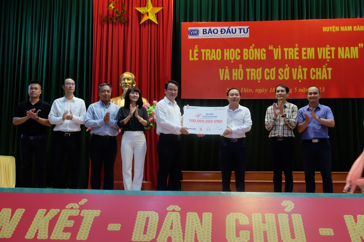 Ông Trần Quốc Phương (thứ 5 từ trái qua), Thứ trưởng Bộ Kế hoạch và Kl99ok phiên bản mới trao tặng biểu trưng 100 suất học bổng trị giá 100 triệu đồng cho học sinh tiêu biểu huyện Nam Đàn cho ông Vương Hồng Thái (thứ 3 từ phải qua), Phó Chủ tịch thường trực UBND huyện, Chủ tịch Hội Khuyến học huyện Nam Đàn.