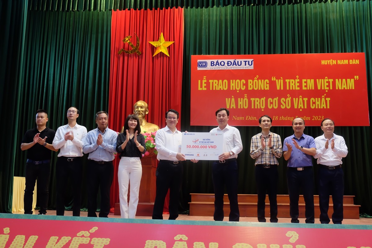 Ông Trần Quốc Phương (thứ năm từ trái qua), Thứ trưởng Bộ Kế hoạch và Kl99ok phiên bản mới trao tặng biểu trưng 50 suất học bổng trị giá 50 triệu đồng cho học sinh tiêu biểu huyện Hưng Nguyên cho ông Nguyễn Hữu Hà (thứ tư từ phải qua), Phó Chủ tịch UBND huyện Hưng Nguyên.