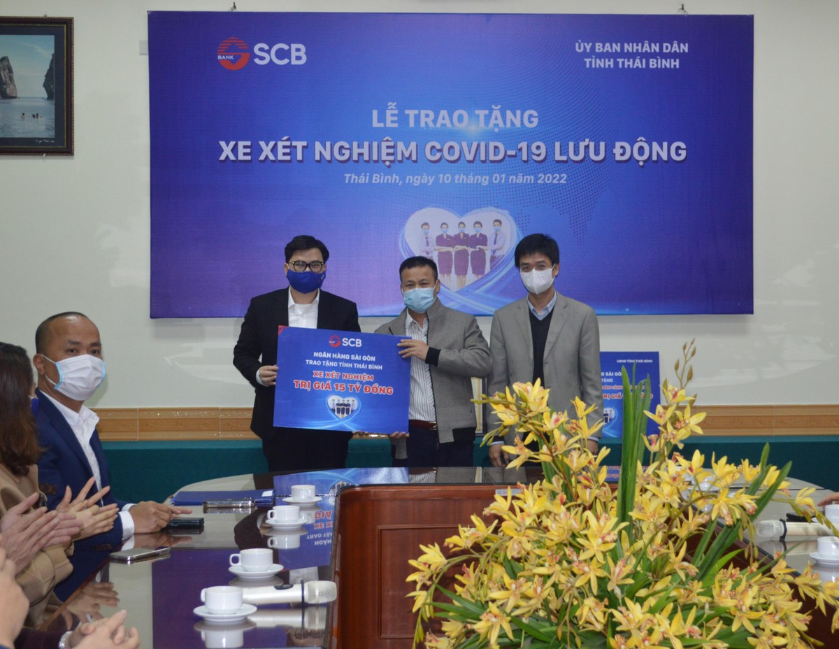Ông Trương Khánh Hoàng, Quyền Tổng Giám đốc SCB trao bảng tượng trưng tặng xe xét nghiệm Covid cho ông Nguyễn Văn Thơm, Giám đốc CDC Thái Bình.