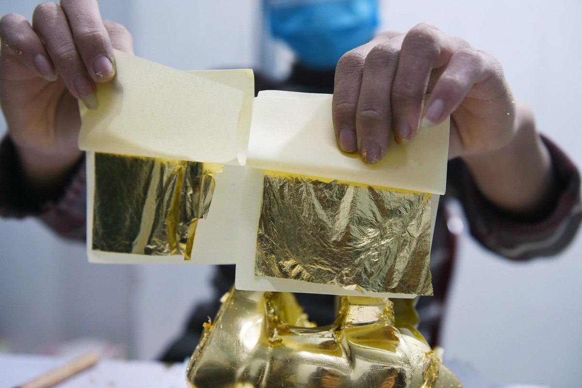 2 lá vàng 24K đang chuẩn bị được dát vào thân tượng.
