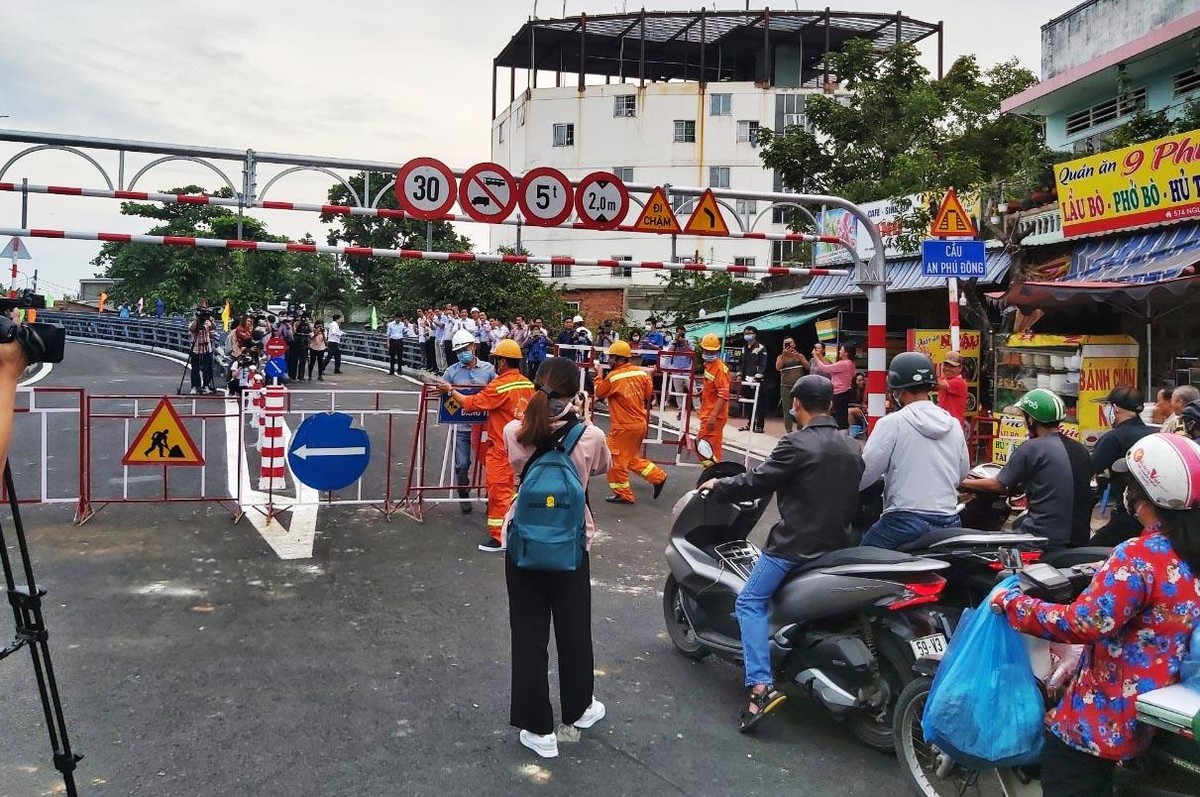 Những phương tiện đầu tiên lưu thông qua cầu thép An Phú Đông khi tấm chắn hai đầu cầu được gỡ bỏ.