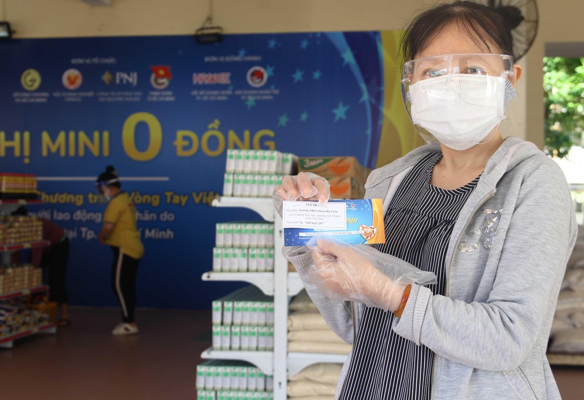 Chị Phạm Thị Dung, lao động bị ảnh hưởng dịch Covid-19,cầm trên tay tấm vé mở hàng siêu thị 0 đồng.