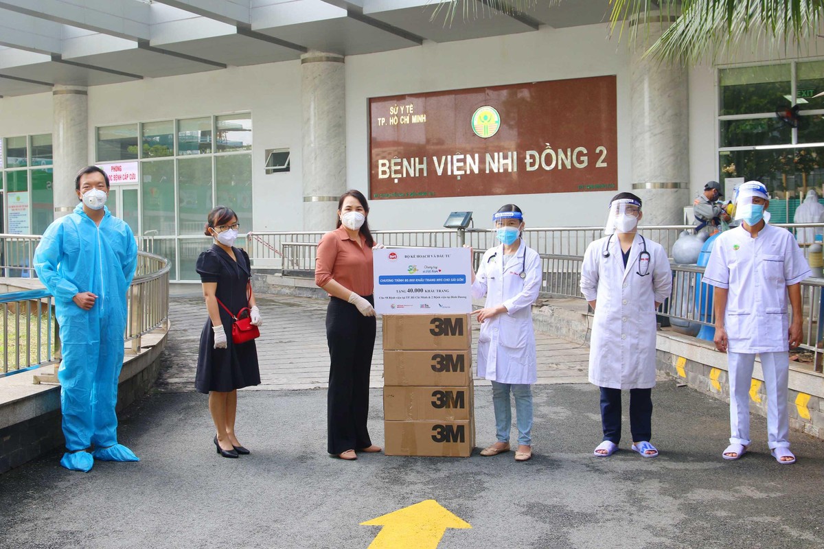 Bác sỹ Đỗ Thị Thúy Hằng (cầm bảng, phải) Khoa Tim Mạch của Bệnh viện Nhi đồng 2, nhận số khẩu trang từ bà Nguyễn Thị Toại, Trưởng đại diện Văn phòng phía Nam Bộ Kế hoạch và Kl99ok phiên bản mới tại TP.HCM vào sáng 30/8. Ảnh: Lê Toàn