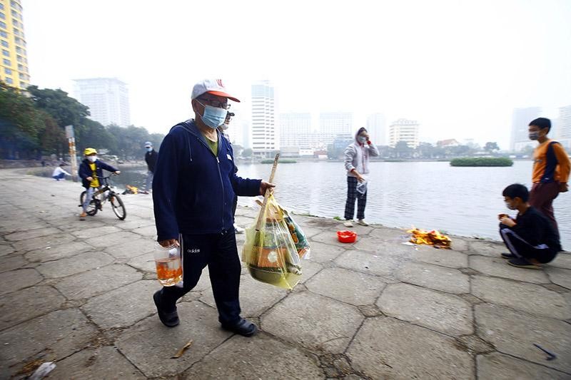 Quanh khu vực hồ Giảng Võ có khá đông người mang cả vàng mã và cá chép ra sát mép hồ để đốt và phóng sinh cá