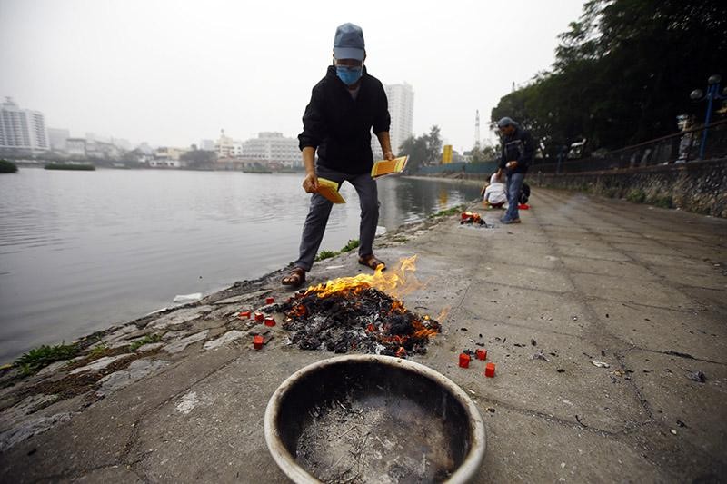 Người lớn tuổi thì cẩn thận hơn khi mang theo cả thau để đốt vàng mã, nhưng do số lượng vàng mã nhiều nên cũng để ra mép hồ rồi đốt