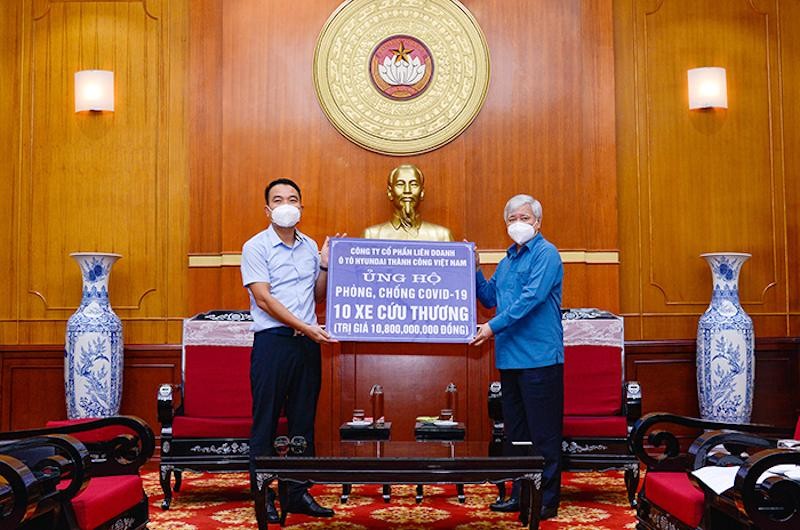 Ông Lê Ngọc Đức (bên trái) trao tặng xe cứu thương cho Mặt trận Tổ quốc Việt Nam
