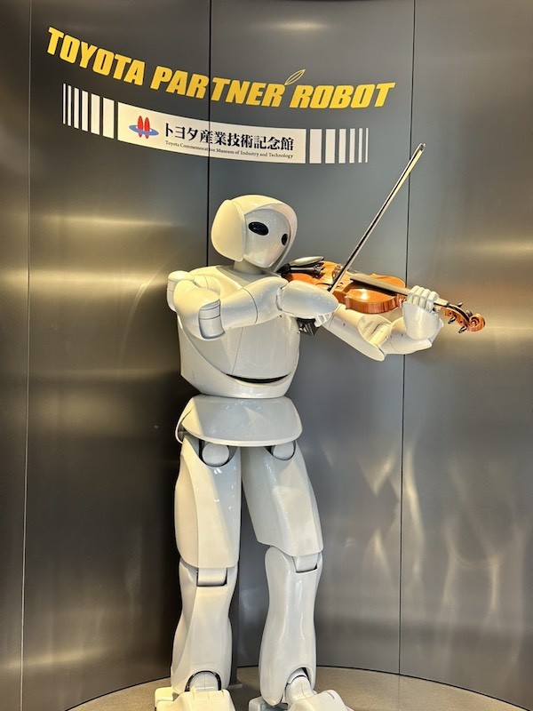 Partner Robot kéo đàn violin cho khách tham quan bảo tàng nghe.