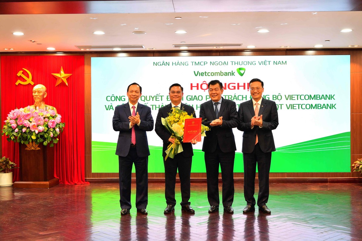Ông Nguyễn Đức Phong - Phó Bí thư Đảng ủy Khối DNTW (thứ 2 từ phải sang) cùng ông Đào Minh Tú - Phó Thống đốc thường trực NHNN Việt Nam (ngoài cùng bên trái) và ông Phạm Quang Dũng - Bí thư Đảng ủy, Chủ tịch HĐQT Vietcombank (ngoài cùng bên phải) trao quyết định và tặng hoa chúc mừng ông Nguyễn Thanh Tùng
