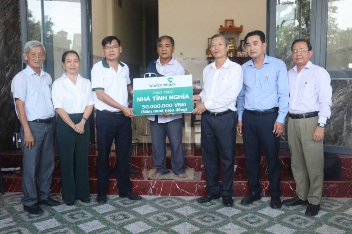 Ông Bùi Hoàng Anh - Chủ tịch Công đoàn cơ sở, Phó Giám đốc Vietcombank Bình Thuận (thứ 3 từ phải sang) cùng lãnh đạo địa phương bàn giao nhà tình nghĩa cho hộ ông Lại Văn Năm