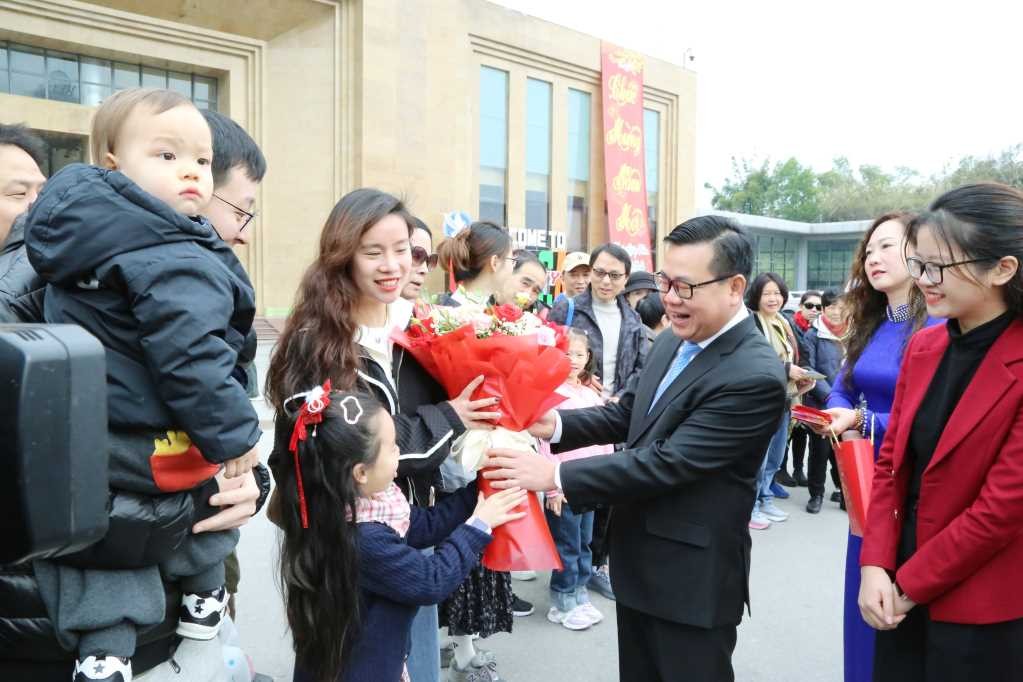 Ông Hoàng Bá Nam, Bí thư Thành ủy Móng Cái tặng hoa chúc mừng những vị khách quốc tế đầu tiên tới xông đất trong ngày đầu năm mới. Nguồn: Quảng Ninh Portal.