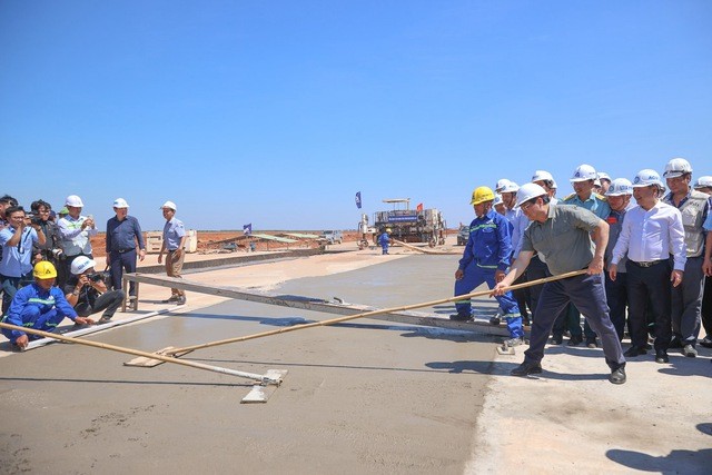 Thủ tướng Phạm Minh Chính (bên phải) cùng thi công với công nhân một hạng mục tại Dự án sân bay Long Thành ngày mùng 4 Tết - Ảnh: VGP/Nhật Bắc