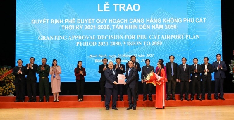 Thứ trưởng Bộ Kế hoạch và Kl99ok phiên bản mới Đỗ Thành Trung (bên trái) trao Quyết định Quy hoạch Cảng hàng không Phù Cát cho Chủ tịch UBND tỉnh Bình Định Phạm Anh Tuấn.