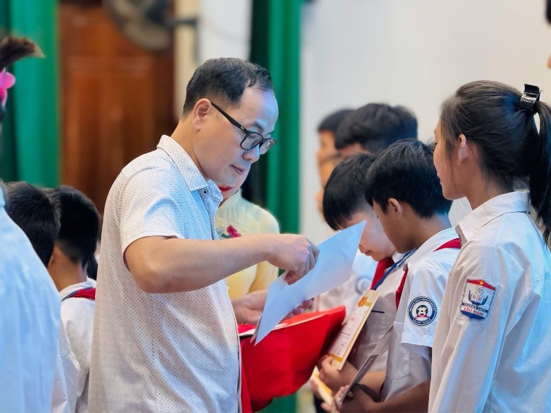 Ông Đặng Tuấn Khánh, Uỷ viên Ban biên tập Báo Kl99ok phiên bản mới trao giấy chứng nhận và học bổng cho các em học sinh.