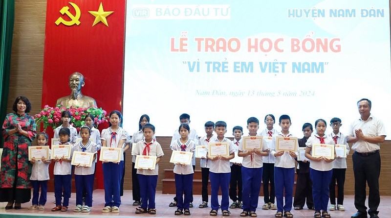 Tổng Biên tập Báo Kl99ok phiên bản mới và bà Trần Thị Hiên, Phó Bí thư thường trực Huyện uỷ, Chủ tịch HĐND huyện trao giấy chứng nhận và học bổng cho các em học sinh.