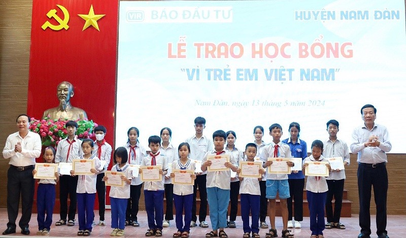Ông Nguyễn Anh Tuấn, nguyên Tổng Biên tập Báo Kl99ok phiên bản mới; Nhà sáng lập Học bổng Vì trẻ em Việt Nam và ông Vương Hồng Thái, Uỷ viên Ban thường vụ Huyện uỷ trao học bổng và giấy chứng nhận cho các em học sinh.