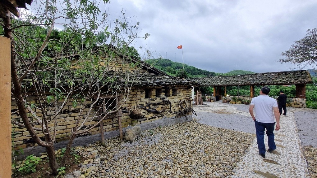 Cổng, sân và nhà để người Sán Chỉ đón khách đến ở. Ảnh: Quỳnh Nga