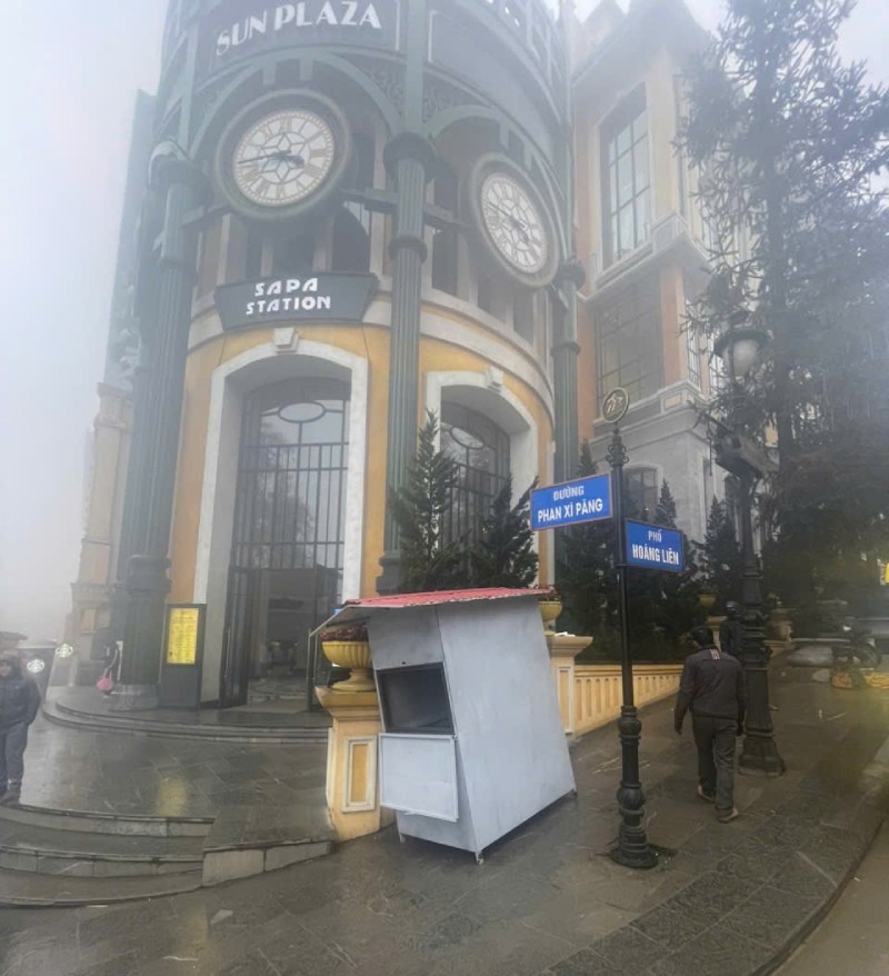 Lực lượng chức năng đang lắp đặt trạm thu phí có camera giám sát và barie tại vỉa hè trước cổng tòa nhà Sun Plaza.