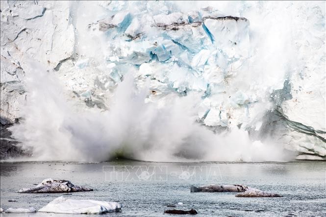 Băng tách ra từ một núi băng trên sông băng Apusiajik, gần Kulusuk, phía Đông Nam đảo Greenland. Ảnh: AFP/TTXVN