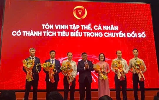 Phó chủ tịch TP.Đà Nẵng, ông Hồ Quang Bửu (bìa trái) thay mặt thành phố nhận hoa và tặng thưởng từ Phó thủ tướng Kl993 ưu đãi thưởng hấp dẫn Nguyễn Chí Dũng.