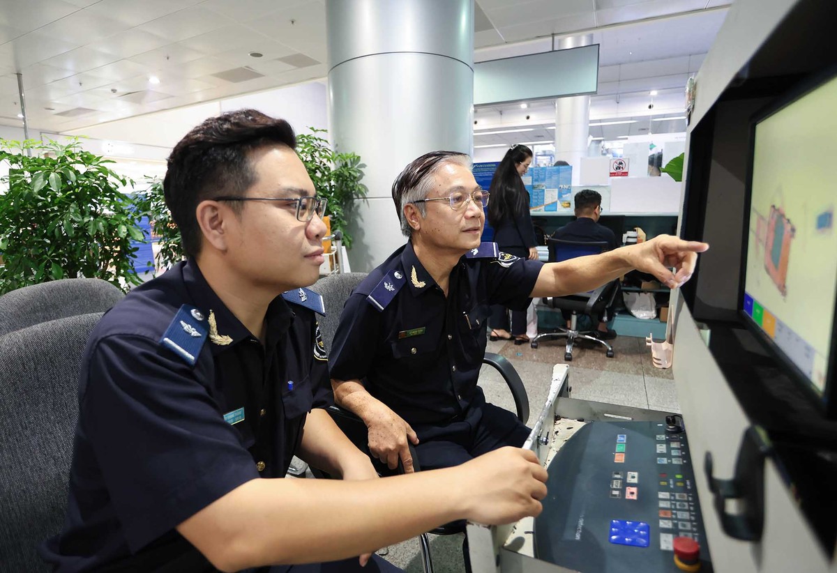Những nhân viên hải quan có kinh nghiệm theo dọi máy soi hành lý.