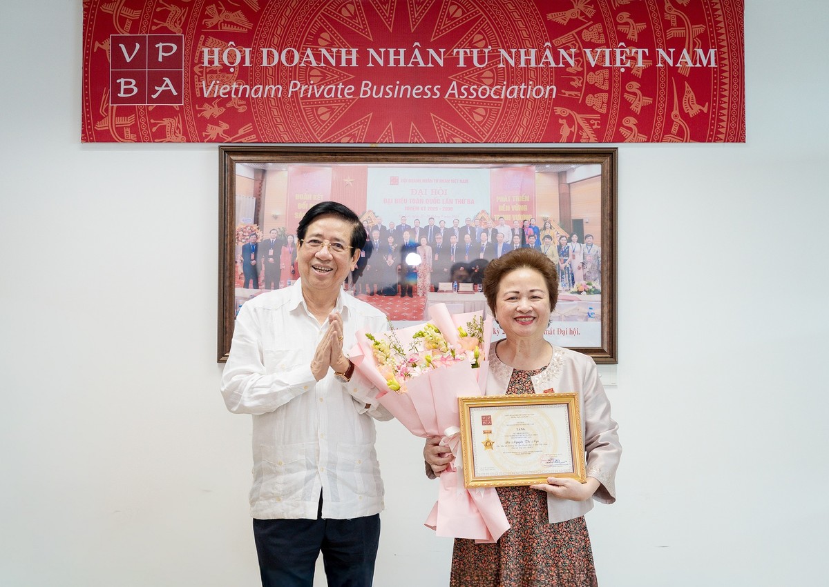 PGS.TS Nguyễn Trọng Điều, Chủ tịch Hội Doanh nhân Tư nhân Việt Nam, trao kỷ niệm chương cho bà Nguyễn Thị Nga