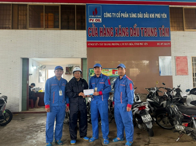 Ông Trần Văn Hay - Phó giám đốc, Chủ tịch Công đoàn PVOIL Phú Yên trao thưởng cho anh Nguyễn Duy Luân - nhân viên CHXD Trung Tâm (người mặc đồng phục xanh đứng giữa) đã có hành động dũng cảm cứu người