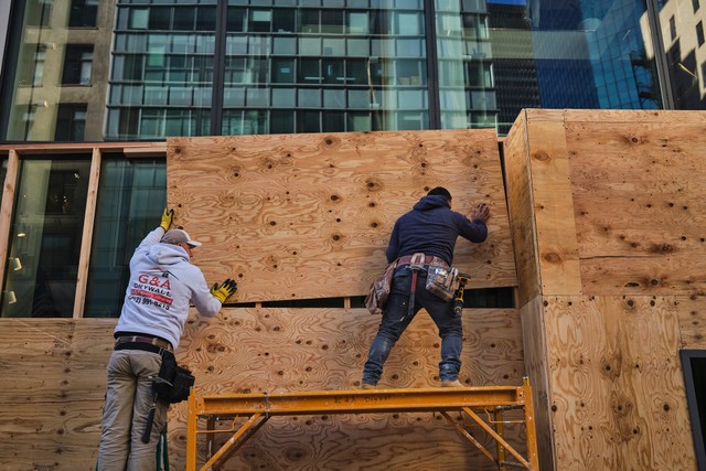 Các công nhân dựng rào chắn các ô cửa tại Manhattan Các công nhân dựng rào chắn các ô cửa tại Manhattan