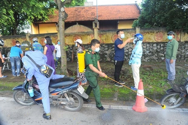 Tiến hành phun khử khuẩn chốt kiểm soát tại lối ra khỏi thành phố Hải Dương. (Ảnh: Mạnh Minh/TTXVN).