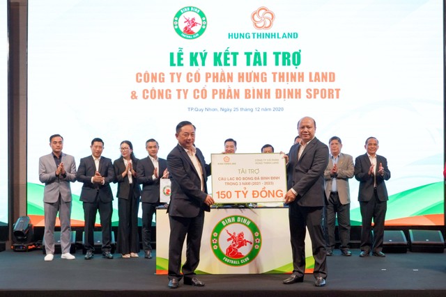 Ông Lê Trọng Khương, Tổng giám đốc Hưng Thịnh Land (phải) trao bảng tài trợ 150 tỷ đồng cho ông Nguyễn Hữu Sang, Giám đốc Công ty cổ phần Bình Định Sport, đại diện đơn vị chủ quản CLB bóng đá Topenland Bình Định.