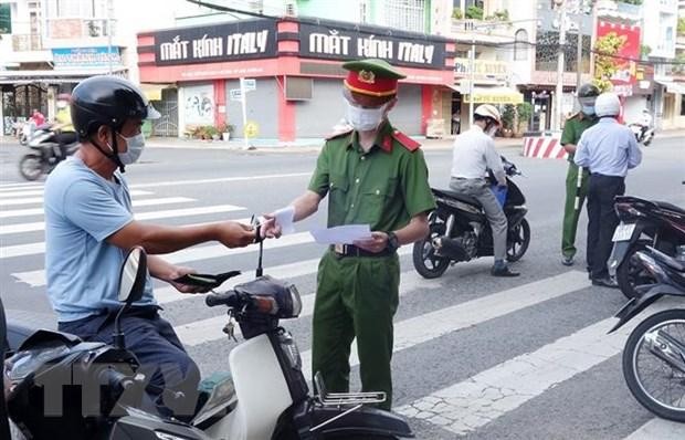 Lực lượng chức năng kiểm tra giấy đi đường của người dân. (Ảnh: Công Mạo/TTXVN).