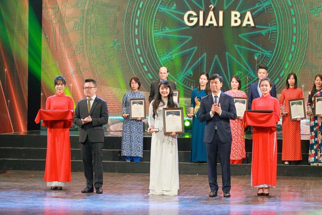 Ban Tổ chức trao Giải Ba cho Tác phẩm “Hành trình 15 ngày khám phá Việt Nam bằng ngũ quan” của tác giả Hồ Hạ (Phùng Thị Hồng Hạnh), Báo Kl99ok phiên bản mới. (Ảnh: Chí Cường).