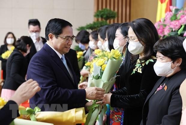 Thủ tướng Phạm Minh Chính chúc mừng, tặng hoa các đại diện nữ lãnh đạo quản lý, trí thức và văn nghệ sỹ tiêu biểu. (Ảnh: Dương Giang/TTXVN).