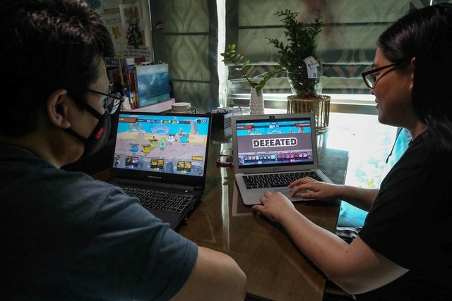 Một cặp vợ chồng ở khu vực ngoại ô Manila đang truy cập website của Axie Infinity.