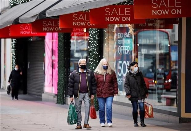 Người dân di chuyển trên một phố mua sắm ở London, Anh. (Ảnh: AFP/TTXVN)