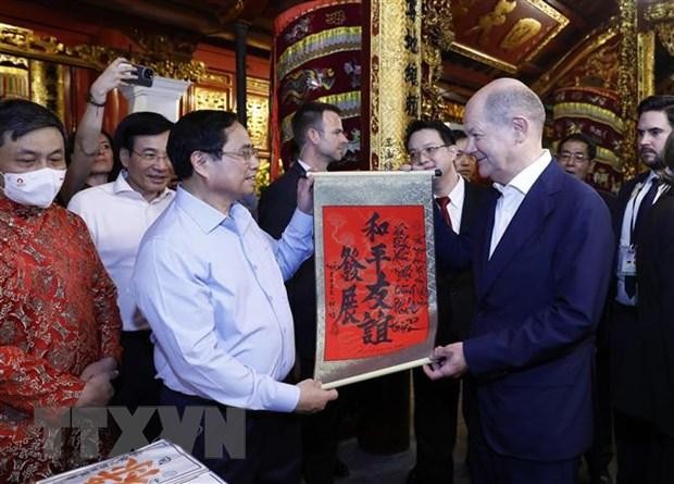 Thủ tướng Phạm Minh Chính tặng Thủ tướng Đức Olaf Scholz bức thư pháp với nội dung "Hòa bình - Hữu nghị cùng phát triển" tại đền Ngọc Sơn.(Ảnh: An Đăng/TTXVN).