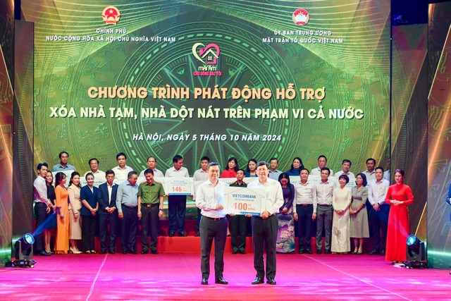 Ông Nguyễn Thanh Tùng (bên trái) - Chủ tịch HĐQT Vietcombank trao biển biểu trưng kinh phí 100 tỷ đồng hỗ trợ xoá nhà tạm, nhà dột nát ủng hộ cho địa phương