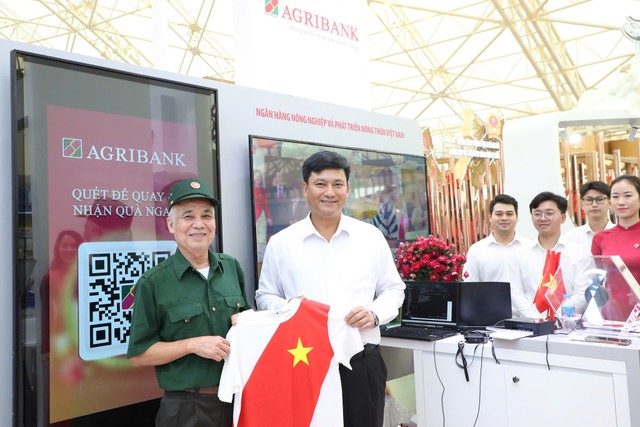 Ông Phạm Toàn Vượng, Tổng giám đốc Agribank tặng quà cho khách đến tham quan gian hàng triển lãm của Agribank Ông Phạm Toàn Vượng, Tổng giám đốc Agribank tặng quà cho khách đến tham quan gian hàng triển lãm của Agribank