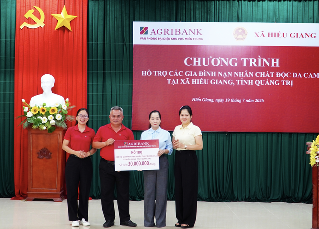 Ông Trần Hữu Trinh - Phó Trưởng Văn phòng khu vực miền Trung trao bảng tượng trưng hỗ trợ 30 triệu đồng cho các gia đình nạn nhân chất độc da cam tại xã Hiếu Giang