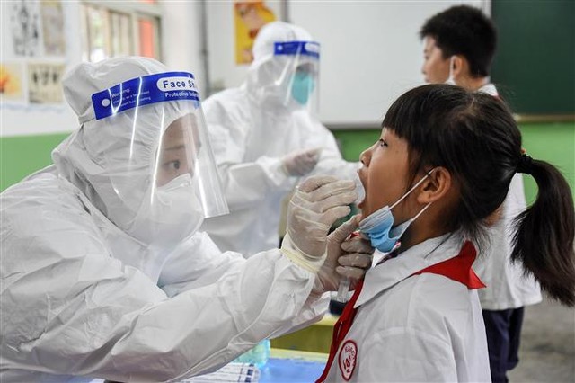 Nhân viên y tế lấy mẫu dịch xét nghiệm COVID-19 cho học sinh tại trường học ở Hàm Đan, tỉnh Hà Bắc, Trung Quốc, ngày 17/8/2020. Ảnh: AFP/ TTXVN