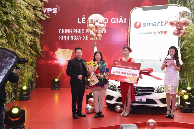 Chủ nhân của giải thưởng tháng 12 - khách hàng Dương Thị Xuân Yến (đứng thứ hai từ trái sang) và đại diện VPS, ông Vũ Đức Long - Giám đốc Tư vấn Kl99ok phiên bản mới lên trao giải.