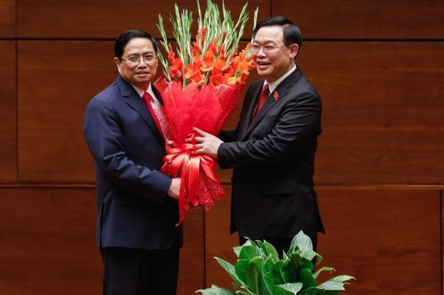 Ông Vương Đình Huệ gửi lời chúc mừng tốt đẹp nhất đến tân Thủ tướng và tặng hoa chúc mừng ông Phạm Minh Chính (Ảnh: Duy Linh)