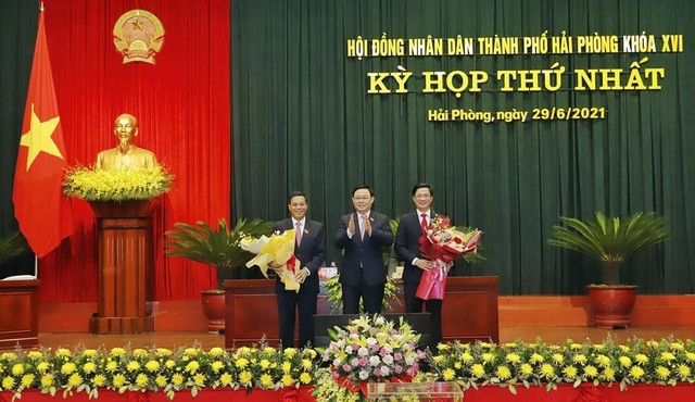 Chủ tịch Quốc hội Vương Đình Huệ tặng hoa chúc mừng ông Phạm Văn Lập (bên phải) trúng cử chức danh Chủ tịch HĐND thành phố Hải Phòng và ông Nguyễn Văn Tùng (bên trái) tái đắc cử chức danh Chủ tịch UBND thành phố Hải Phòng.